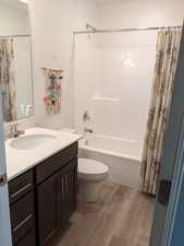 Full bathroom with vanity, light wood-type flooring, and shower / bath combo