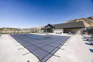 Community pool with a mountain view and a patio area