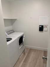 Laundry area featuring light wood-style floors and washing machine and dryer