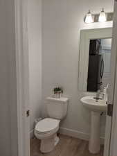 Half bath featuring light wood finished floors and baseboards