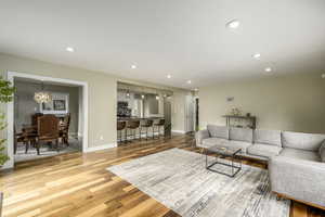 Living room with recessed lighting, a chandelier, and light wood finished floors
