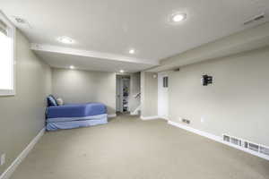 Bedroom with carpet flooring, recessed lighting, and a textured ceiling