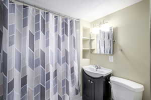 Full bath with a shower with curtain and vanity