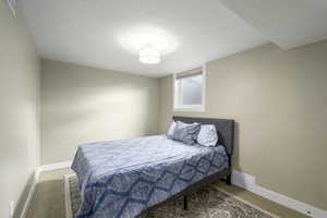 Bedroom featuring baseboards and a textured ceiling