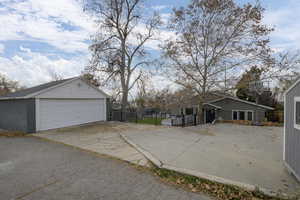View of home's exterior with a two car garage, a patio area, and plenty of space for rv parking.