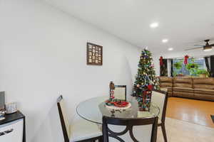 Tiled dining area with recessed lighting and a ceiling fan