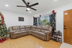 Living room with wood finished floors and a ceiling fan