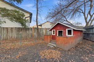 Fenced backyard featuring a deck and a storage shed