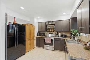 Kitchen with black appliances, light countertops, decorative backsplash, dark brown cabinets, and recessed lighting