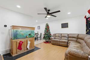 Living room with wood finished floors, ceiling fan, and recessed lighting