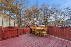 Wooden deck featuring outdoor dining space and a residential view