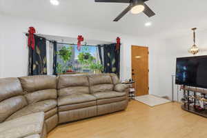 Living room featuring light wood-type flooring and a ceiling fan