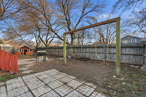 Fenced backyard featuring a patio area, grilling area, and an outdoor structure