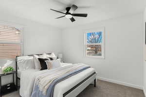 Carpeted bedroom featuring baseboards and a ceiling fan