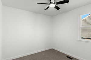 Spare room featuring carpet floors and ceiling fan