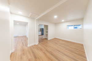 Empty room featuring light wood-style flooring, attic access, and recessed lighting