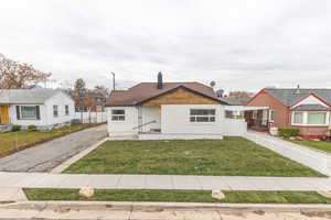 Bungalow-style home featuring a chimney and driveway