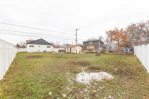 Fenced backyard featuring a shed