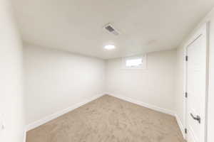 Carpeted spare room with baseboards and a textured ceiling