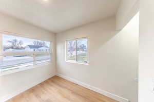 Unfurnished room with light wood finished floors and a textured ceiling