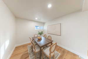 Dining area with light wood finished floors and recessed lighting