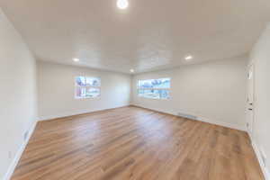 Unfurnished room with light wood-style flooring, recessed lighting, and a textured ceiling