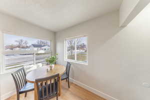 Dining area with light wood-style floors and a textured ceiling