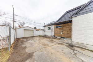 View of home's exterior with a garage, driveway, and an outbuilding