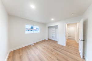 Unfurnished bedroom featuring light wood-type flooring, a closet, and recessed lighting