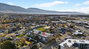 Aerial view of property and surrounding area with a mountainous background and nearby suburban area