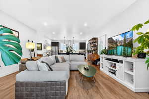 Living room with light wood-style floors and recessed lighting