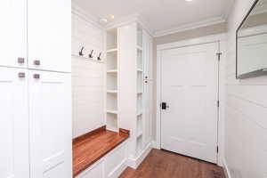 Mudroom featuring ornamental molding and dark wood finished floors