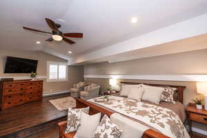 Bedroom featuring dark wood finished floors, vaulted ceiling, baseboard heating, ceiling fan, and recessed lighting