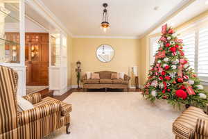 Living area featuring crown molding and wood finished floors