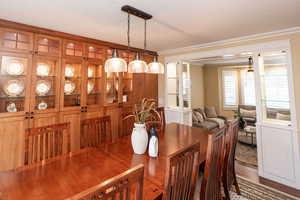 Dining space featuring crown molding, wood finished floors, and a textured ceiling