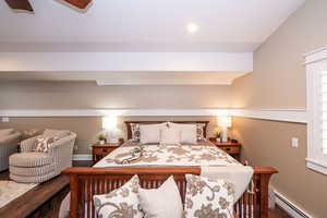 Bedroom with a baseboard radiator, ceiling fan, and wood finished floors