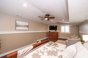 Bedroom with wood finished floors, lofted ceiling, baseboard heating, a ceiling fan, and recessed lighting