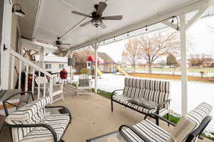 View of patio with a playground, a ceiling fan, and a residential view