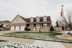 Cape cod house featuring covered porch, brick siding, driveway, a garage, and a shingled roof