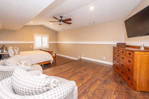 Bedroom featuring dark wood-style floors, lofted ceiling, a ceiling fan, and recessed lighting. This long wall could be opened up to create a large closet or space above the garage. Currently it is just attic which could be converted.