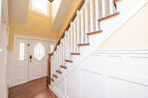 Foyer featuring stairs, dark wood finished floors, and a baseboard heating unit