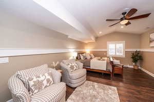 Bedroom with dark wood-type flooring, lofted ceiling, ceiling fan, recessed lighting, and baseboard heating