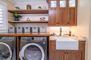 Stunning laundry area featuring independent washer and dryer and cabinet space