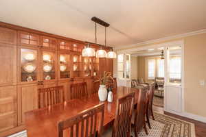 Dining area featuring ornamental molding and light wood-style floors