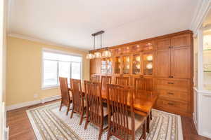 Dining room featuring crown molding, baseboard heating, and wood finished floors