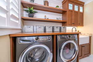 Laundry room featuring washing machine and clothes dryer and cabinet space