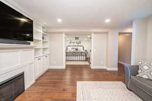 Unfurnished living room with a glass covered fireplace, dark wood-type flooring, and recessed lighting