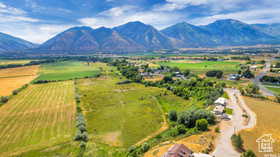 View of rural area with a mountain backdrop and large plots for crops