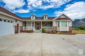 View of front of house featuring covered porch, driveway, and an attached garage