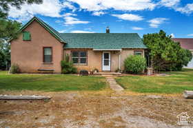 View of front of property featuring a front yard and stucco siding